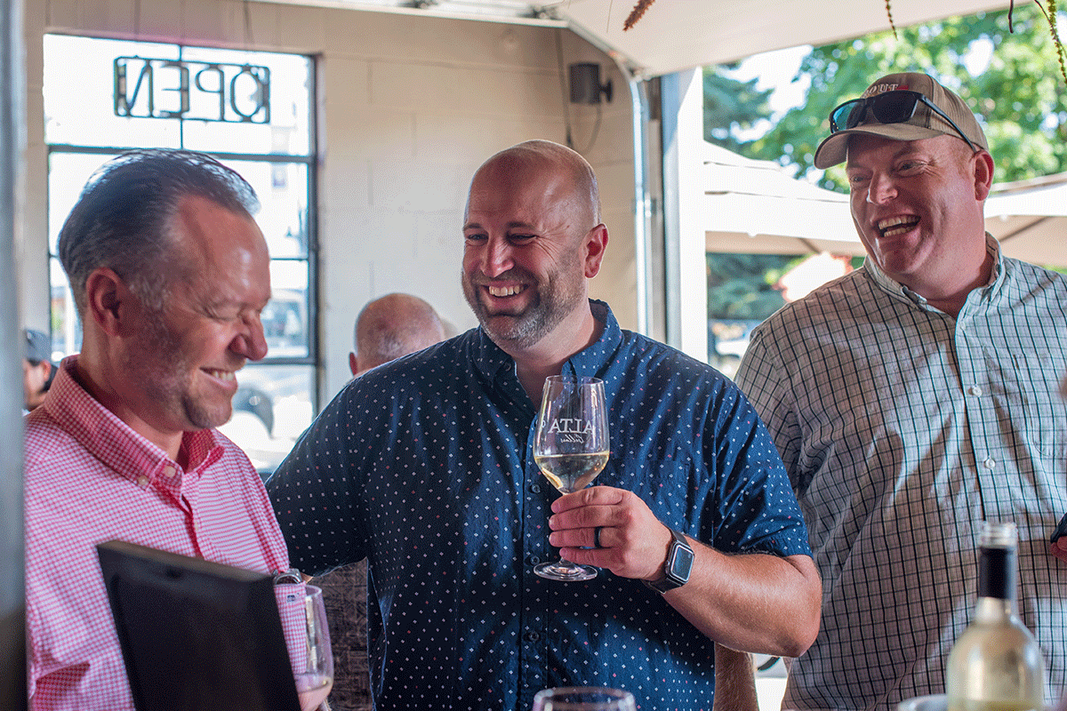 Men laughing drinking wine